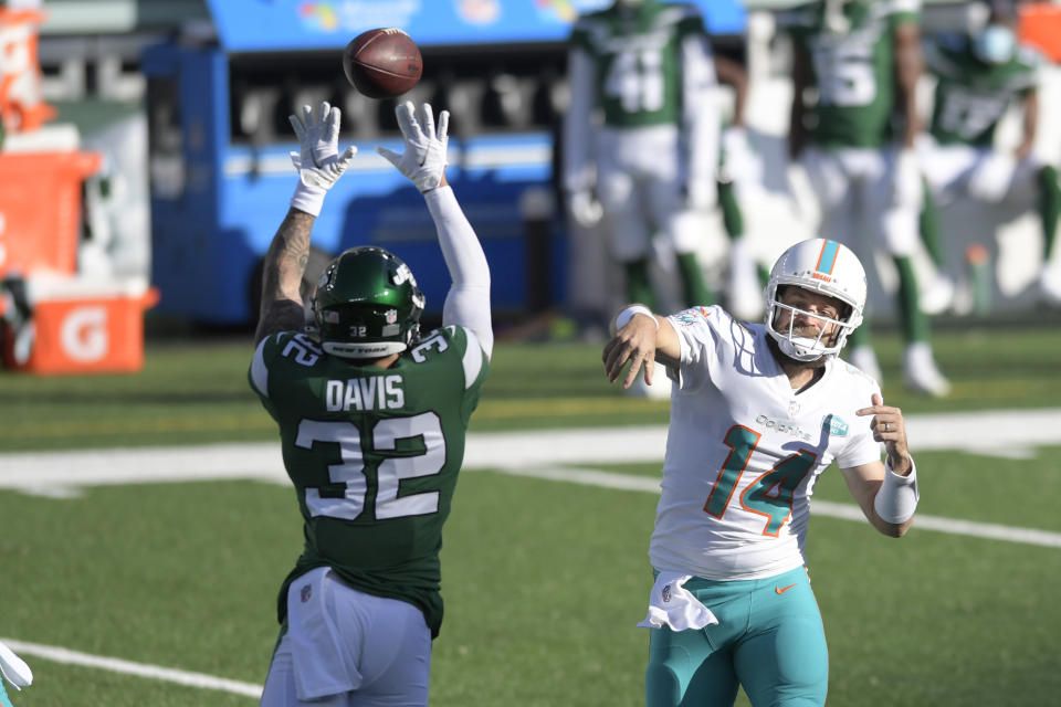 New York Jets' Ashtyn Davis (32), left, tries to block a throw from Miami Dolphins quarterback Ryan Fitzpatrick during the first half of an NFL football game, Sunday, Nov. 29, 2020, in East Rutherford, N.J. (AP Photo/Bill Kostroun)