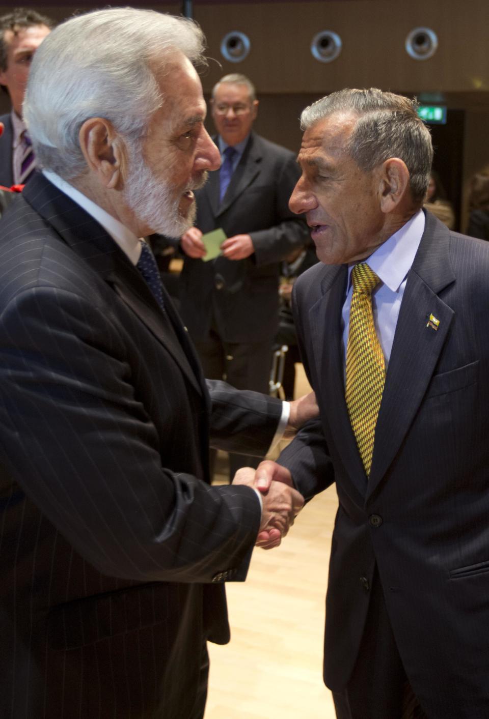 Samuel Santos, minister of foreign affairs of Nicaragua, left, shakes hands with agent Julio Londono Paredes of Colombia, right, as the court delivered its ruling in the case of Nicaragua versus Colombia over ownership of a string of islands and cays off Nicaragua's Caribbean coast, at the International Court of Justice in The Hague, Netherlands, Monday, Nov. 19, 2012. (AP Photo/Peter Dejong)