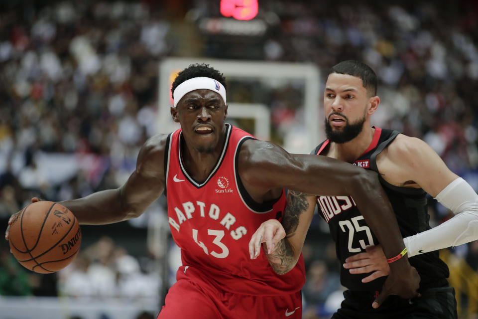 Toronto Raptors' Pascal Siakam, left, is pressured by Houston Rockets' Austin Rivers during the first half of an NBA preseason basketball game Thursday, Oct. 10, 2019, in Saitama, near Tokyo. (AP Photo/Jae C. Hong)