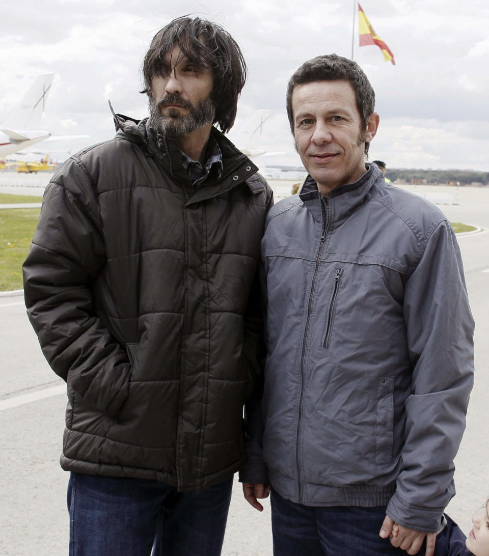 Spanish reporters and Javier Espinosa, right, and Ricardo Garcia Vilanova, pose for a photo upon their arrival at the military airport of Torrejon in Madrid, Spain, Sunday, March 30, 2014. Two Spanish journalists who were freed after being kidnapped for more than six months in Syria by a rogue al-Qaida group are flying back home Sunday, Spain’s Defense Ministry said. The El Mundo newspaper reported earlier that its war correspondent Javier Espinosa made contact late Saturday from Turkey, where he and photographer Ricardo Garcia Vilanova were under military protection. (AP Photo/Paco Campos, Pool)