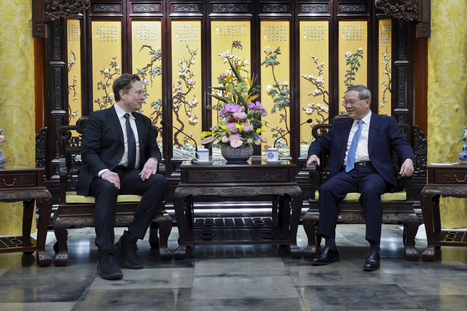 In this photo released by Xinhua News Agency, Tesla founder and CEO Elon Musk, left, meets with Chinese Premier Li Qiang in Beijing, Sunday, April 28, 2024. Musk met with a senior government leader in the Chinese capital on Sunday, just as The country's automakers are showcasing their latest electric vehicle models at the Beijing Auto Show.  (Wang Yi/Xinhua via AP)