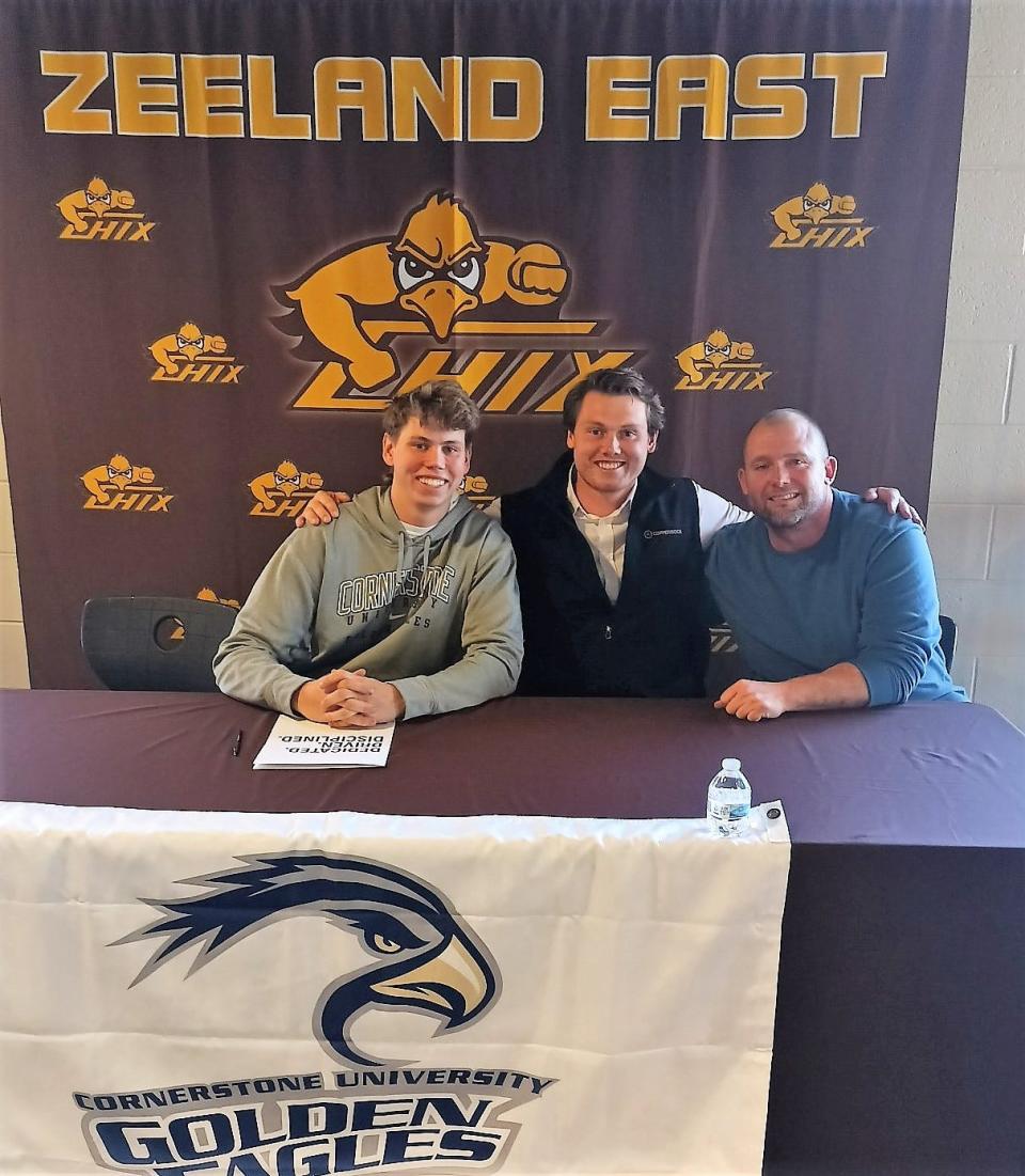 Zeeland East's Evan Berghorst (left) signs with Cornerstone with Johnathan Berghorst and coach Ralph Neal.