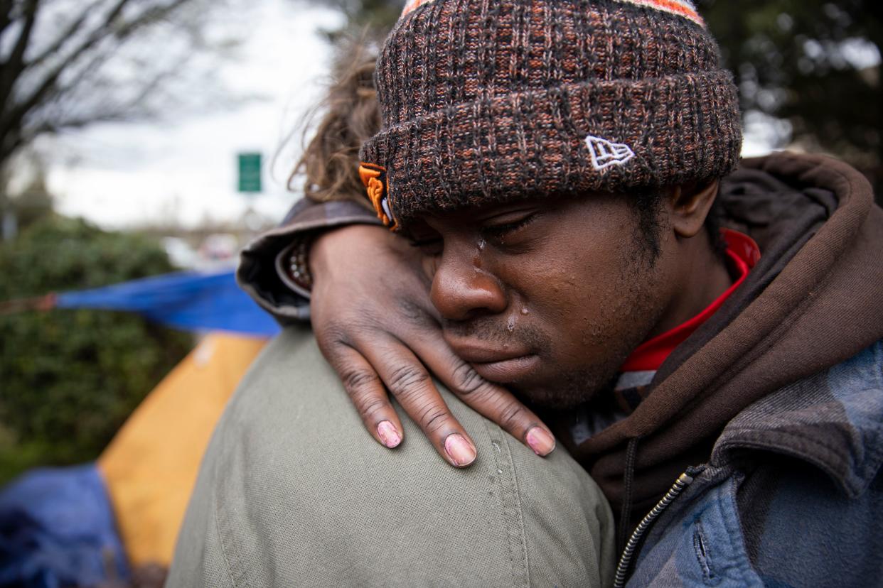 Noland Baliey and Justin Adamson console each other at the site of a car crash that killed four of their friends on Sunday night, in Salem, Ore. on Monday, March 28, 2022. 