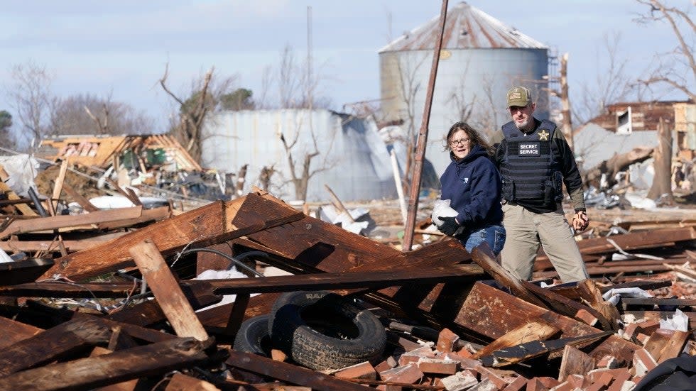 People inspect the remains of a destroyed business Saturday, Dec. 11, 2021, in Mayfield, Ky.