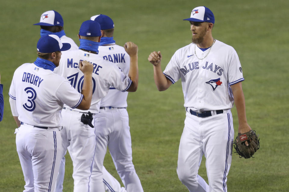 Toronto Blue Jays pitcher, right, celebrates a 12-4 victory over Tampa Bay Rays following the ninth inning of a baseball game, Friday, Aug. 14, 2020, in Buffalo, N.Y. (AP Photo/Jeffrey T. Barnes)