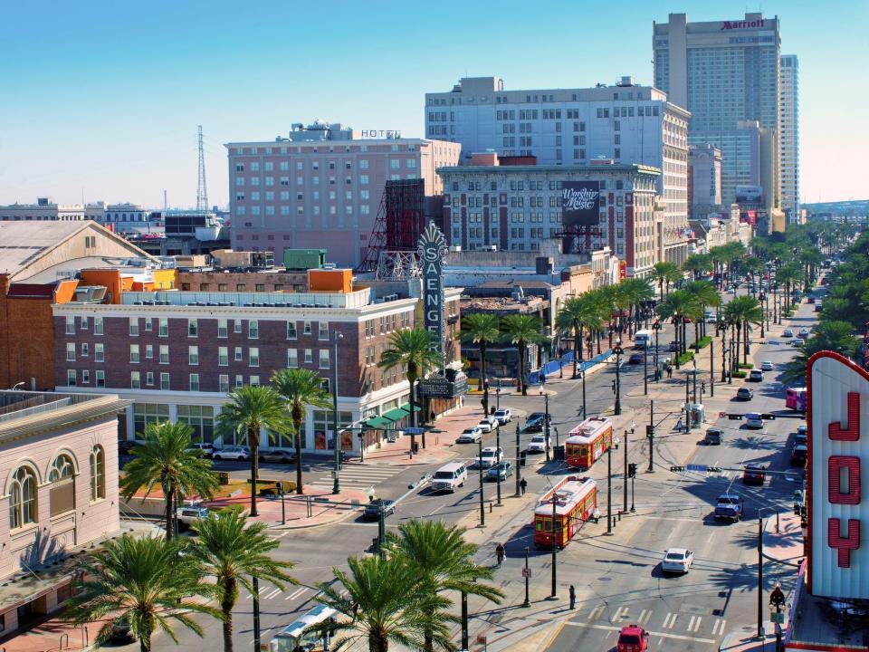 Red street cars on Canal Street pass by the renovated Saenger and Joy Theaters. Canal Street is New Orleans main street with shopping, dining and entertainment.