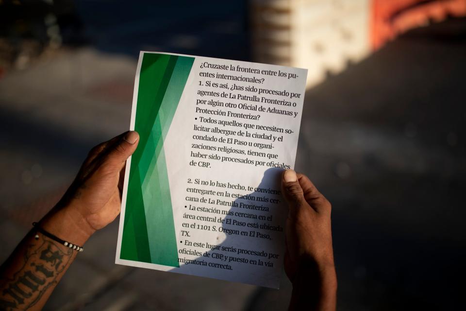 A migrant holds the flyer left on the sidewalk by CBP agents in the early morning as migrants slept outside Sacred Heart Church in El Paso, Texas, Tuesday, May 9, 2023. The flyer encouraged migrants to turn themselves in at the nearest substation.