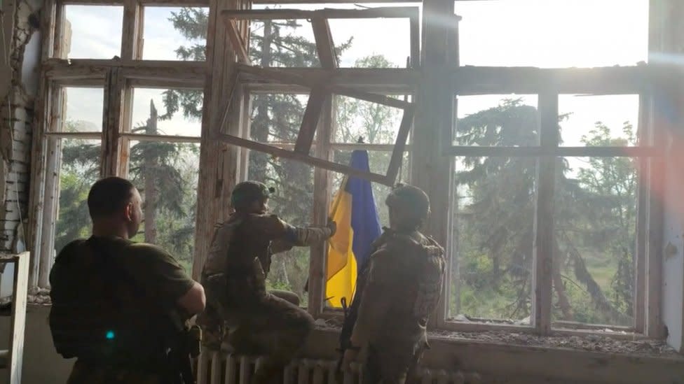 Soldados ucranianos colocan una bandera nacional de su país en un edificio destruido en Blahodatne, Ucrania oriental. 11 de junio de 2023