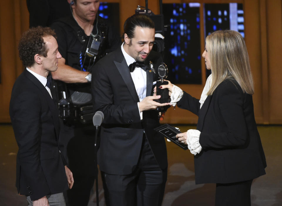 FILE - In this June 12, 2016 file photo Barbra Streisand, right, presents the award for best musical to Lin-Manuel Miranda, center, of "Hamilton," as producer Jeffrey Seller looks on at the Tony Awards in New York. A filmed version of the original Broadway production will be available Friday, July 3, on Disney Plus. (Photo by Evan Agostini/Invision/AP, File)
