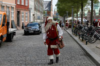 <p>A man dressed as Santa Claus walks through the streets between events for the World Santa Claus Congress, an annual event held every summer in Copenhagen, Denmark, July 23, 2018. (Photo: Andrew Kelly/Reuters) </p>