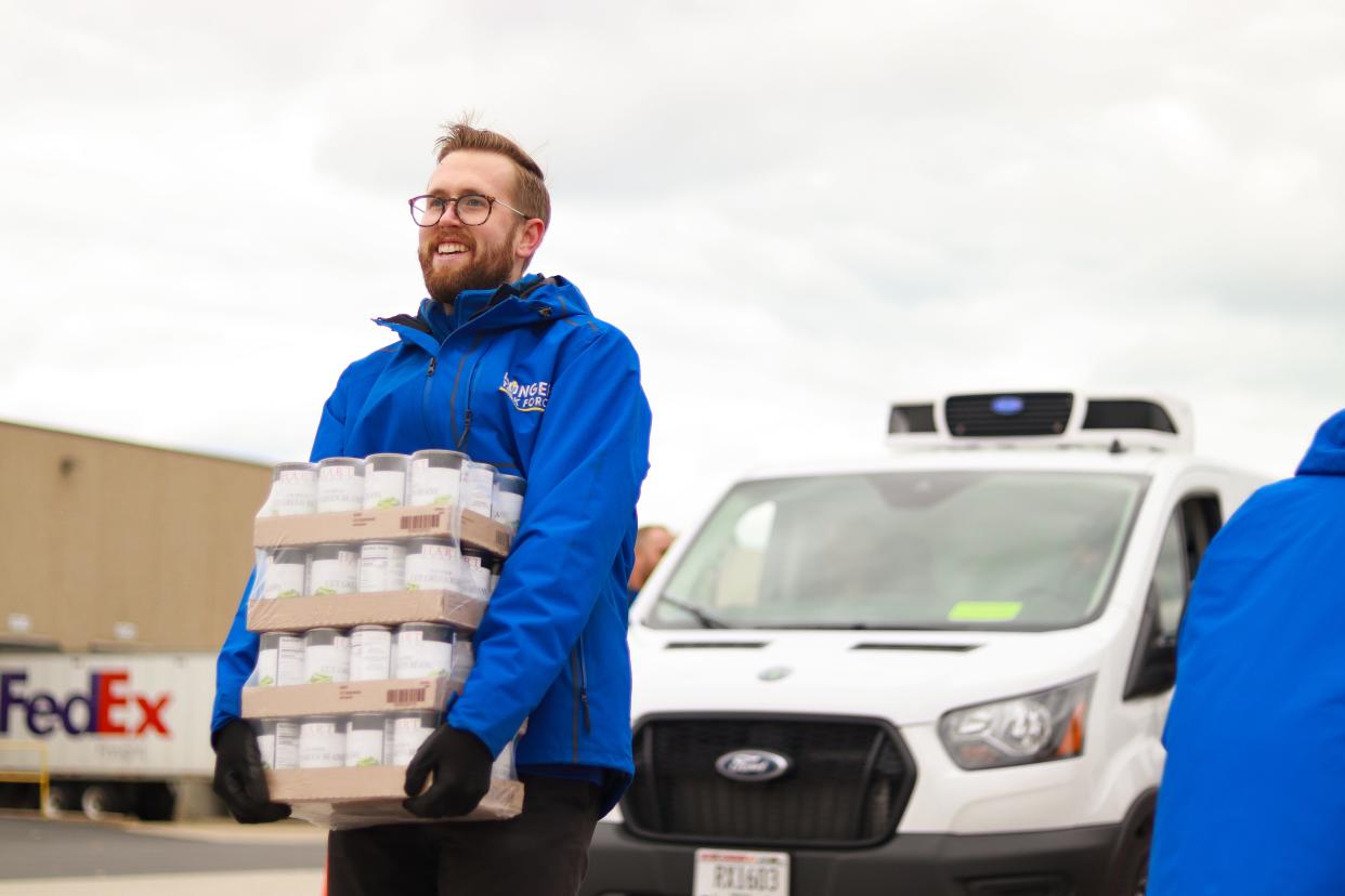 Cans of food are carried across a parking lot in Milwaukee County, as part of the Hunger Task Force's food donations programs.