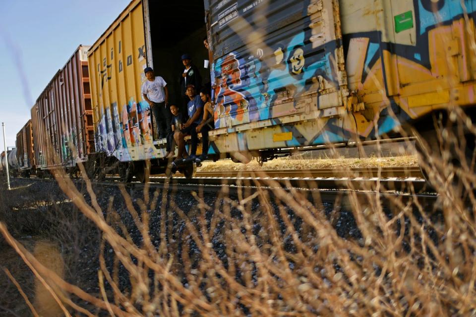 Migrants travel on a train (Reuters)