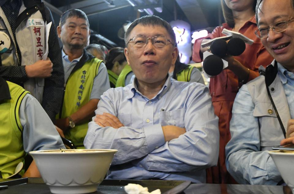 This picture taken on November 9, 2018 shows independent Taipei mayor candidate Ko Wen-je (C) listening to a reporter during his lunch at a traditional market in Taipei. - When Taiwan goes to the polls on November 24, 2018 in local elections, it will not only be a test for President Tsai Ing-wen's embattled government but a crucial vote on divisive issues that could rile China. (Photo by SAM YEH / AFP) / TO GO WITH STORY: Taiwan-China-vote-referendum-politics, ADVANCER by Amber WANG        (Photo credit should read SAM YEH/AFP/Getty Images)