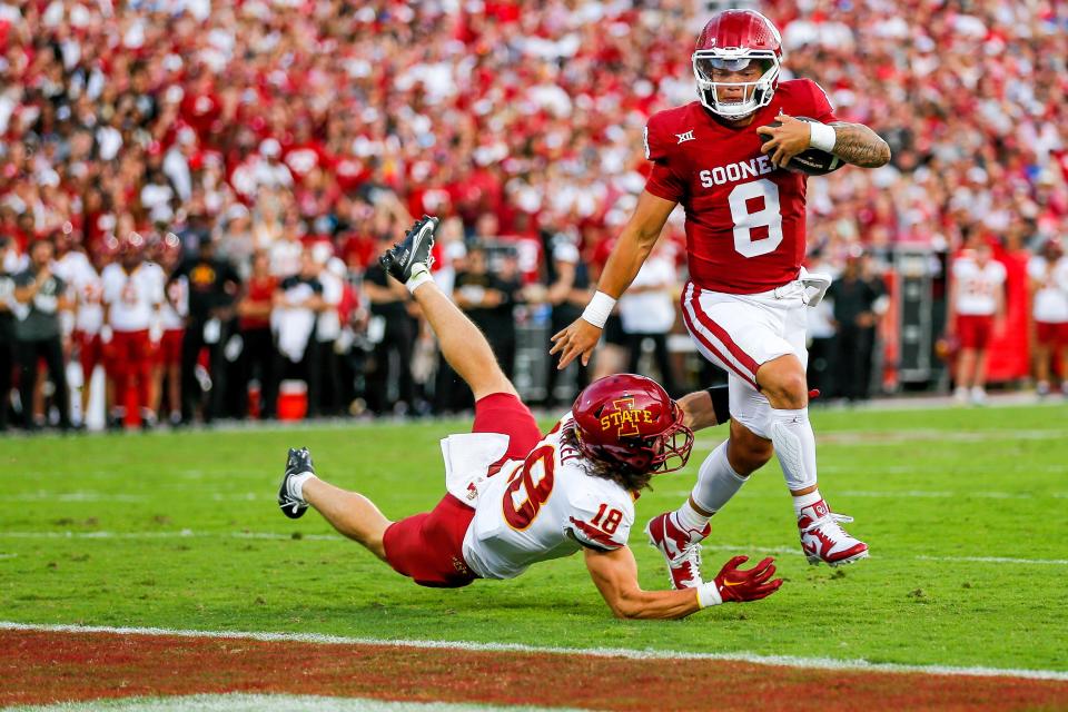 Oklahoma's Dillon Gabriel (8) leaps over Iowa State's Ben Nikkel (18) to score a touchdown in the first quarter at the Gaylord Family Oklahoma Memorial Stadium in Norman, Okla., on Sept. 30.