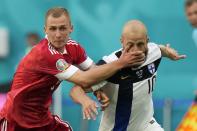 Russia's Dmitri Barinov, left, fouls Finland's Teemu Pukki during the Euro 2020 soccer championship group B match between Russia and Finland at the Saint Petersburg stadium, in St. Petersburg, Russia, Wednesday, June 16, 2021. (AP Photo/Dmitri Lovetsky, Pool)