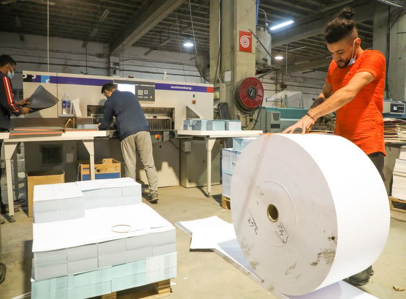 Workers work at Oriental Paper Products, a stationery factory in Fanar