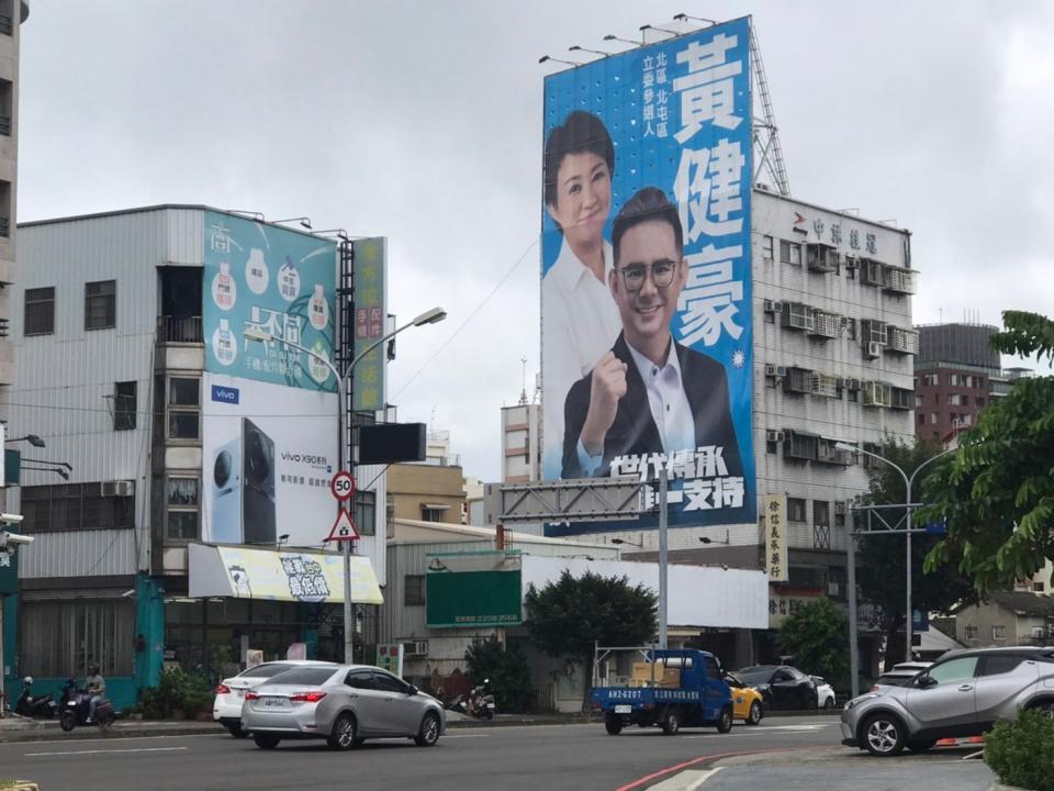 國民黨提名的黃健豪選擇與市長盧秀燕合照，並在路口設置大型看板。王乙徹攝