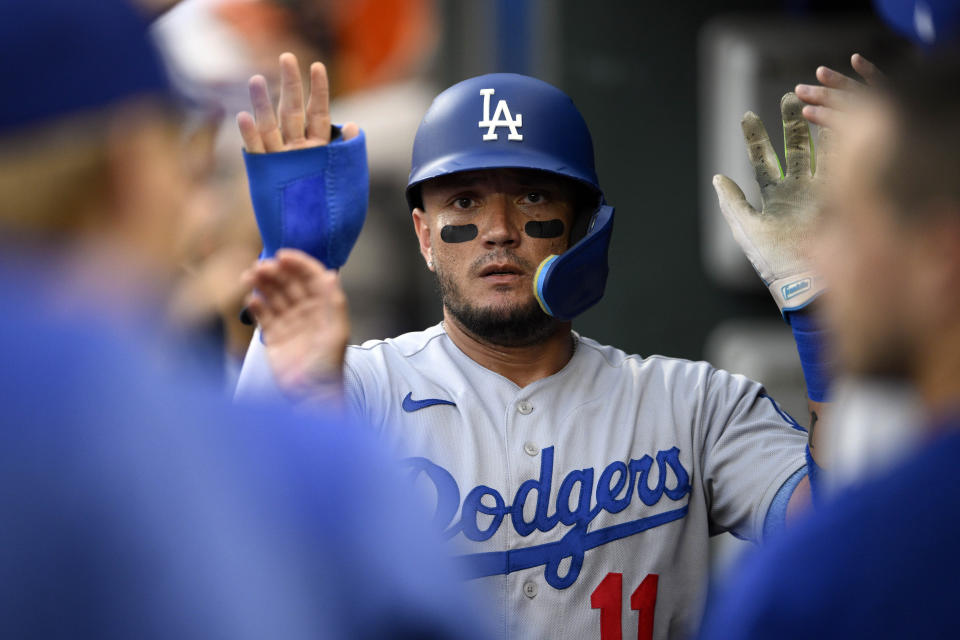 Los Angeles Dodgers' Miguel Rojas celebrates in the dugout after he scored on a single by Freddie Freeman during the second inning of a baseball game against the Baltimore Orioles, Tuesday, July 18, 2023, in Baltimore. (AP Photo/Nick Wass)