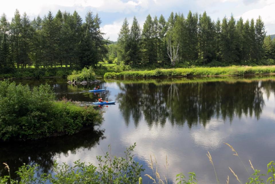 In this Aug. 11, 2013 photo, paddlers move through placid waters from the P'tit Train du Nord rail trail outside Montreal, Quebec. The rail trail cuts through stands of hardwood and softwood forests, along lakes and rushing rivers, with inns and cafes along the way. (AP Photo/Calvin Woodward)