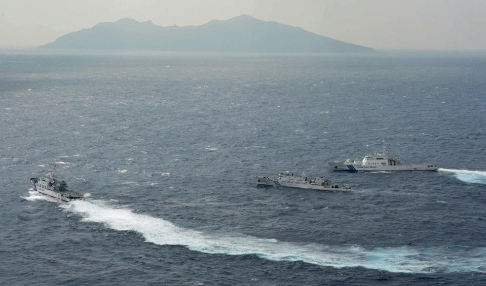 Japan Coast Guard vessels sail along with Chinese surveillance ship Haijian No. 66, center, near disputed islands called Senkaku in Japan and Diaoyu in China, seen in background, in the East China Sea, on Monday, Sept. 24, 2012. (AP Photo/Kyodo News) JAPAN OUT, MANDATORY CREDIT, NO LICENSING IN CHINA, HONG KONG, JAPAN, SOUTH KOREA AND FRANCE