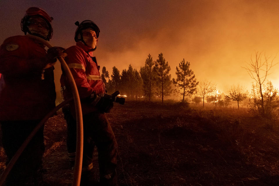 Members of the emergency services try to extinguish a wildfire near Cardigos village, in central Portugal on Sunday, July 21, 2019. About 1,800 firefighters were struggling to contain wildfires in central Portugal that have already injured people, including several firefighters, authorities said Sunday. (AP Photo/Sergio Azenha)