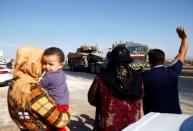 People greet a Turkish military convoy near the Turkish-Syrian border in Sanliurfa province