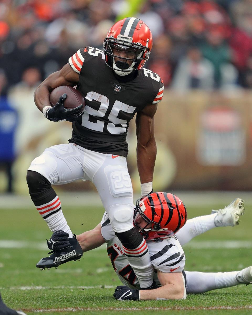 Cleveland Browns running back Demetric Felton (25) rushes for yards as he is brought down by Cincinnati Bengals linebacker Clay Johnston (44) during the first half of an NFL football game, Sunday, Jan. 9, 2022, in Cleveland, Ohio. [Jeff Lange/Beacon Journal]