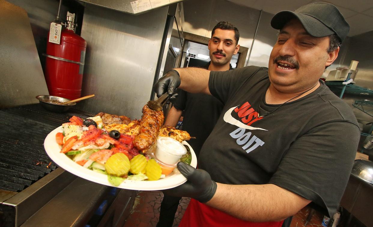 Owner Mastafa Kocaman puts together a plate of Turkish food in the kitchen at Mustafa’s Place on West Virginia Avenue in Bessemer City.