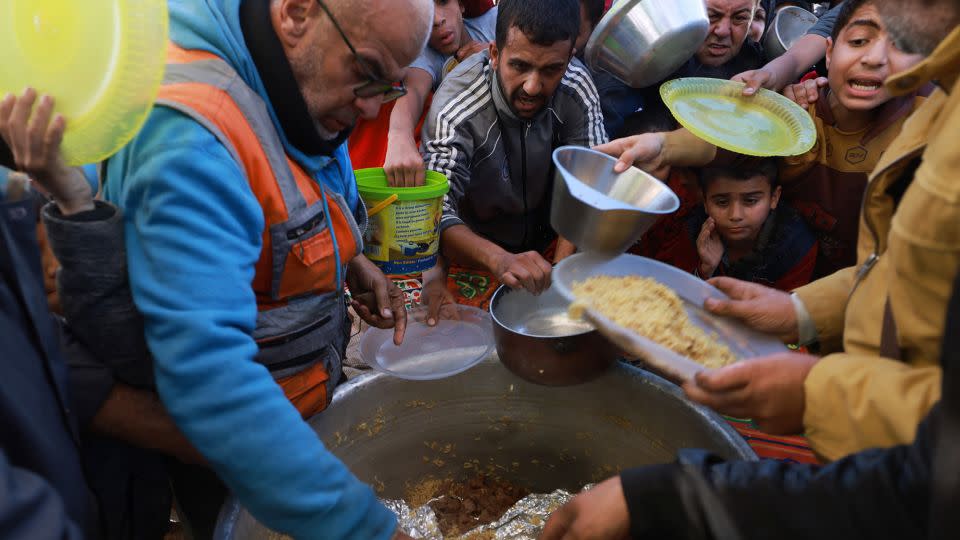 Displaced Palestinians queue for food donations in Rafah, in southern Gaza, on November 30. Rampant food, fuel and water shortages have led to spiraling prices. - Mohammed Abed/AFP/Getty Images
