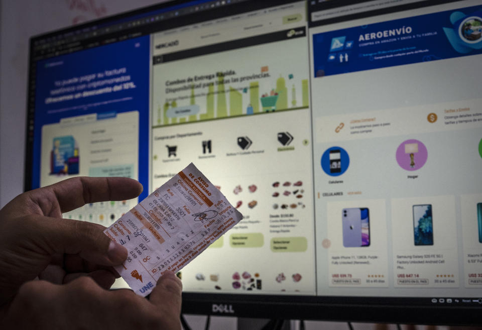 Erich García, a programmer specializing in cryptocurrencies and is an administrator of electronic commerce pages, shows how an electricity bill can be paid through cryptocurrency systems and electronic payments in Havana, Cuba, Friday, May 20, 2022. Some people have used those virtual currencies like Bitcoin to shift money to Cubans electronically. Garcia estimated that about 100,000 have cryptocurrency accounts. (AP Photo/Ramon Espinosa)