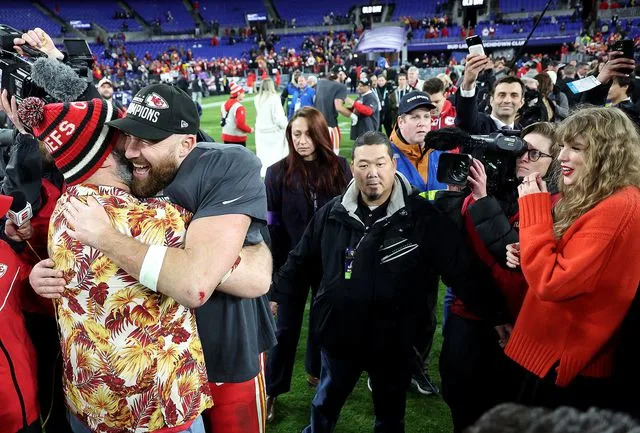 <p>Rob Carr/Getty</p> Travis Kelce #87 of the Kansas City Chiefs celebrates with his brother Jason Kelce as Taylor Swift looks on