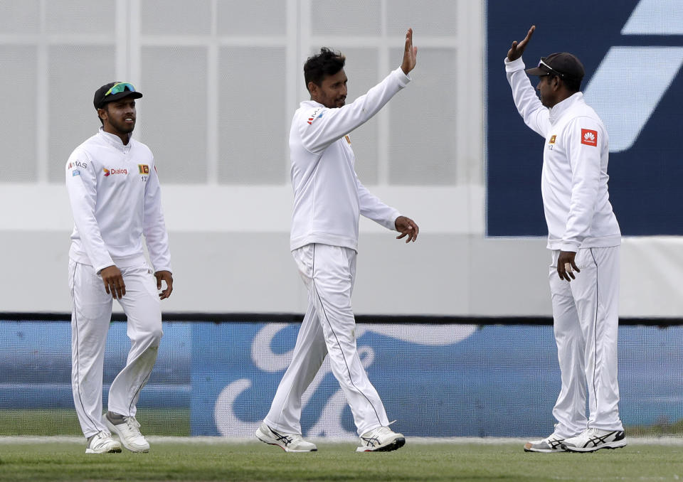 Sri Lanka's Suranga Lakmal, centre, is congratulated by teammates after taking a catch to dismiss New Zealand's Ajaz Patel during play on day one of the second cricket test between New Zealand and Sri Lanka at Hagley Oval in Christchurch, New Zealand, Wednesday, Dec. 26, 2018. (AP Photo/Mark Baker)