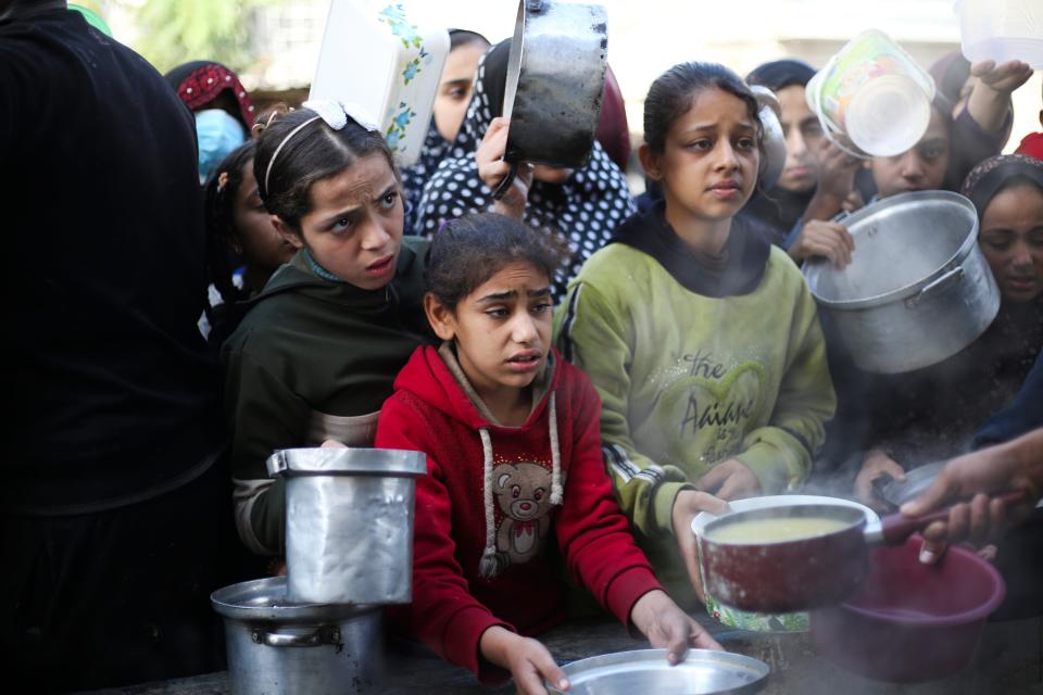 Palestinians line up for a meal in Rafah, Gaza Strip, Wednesday, Dec. 20, 2023.