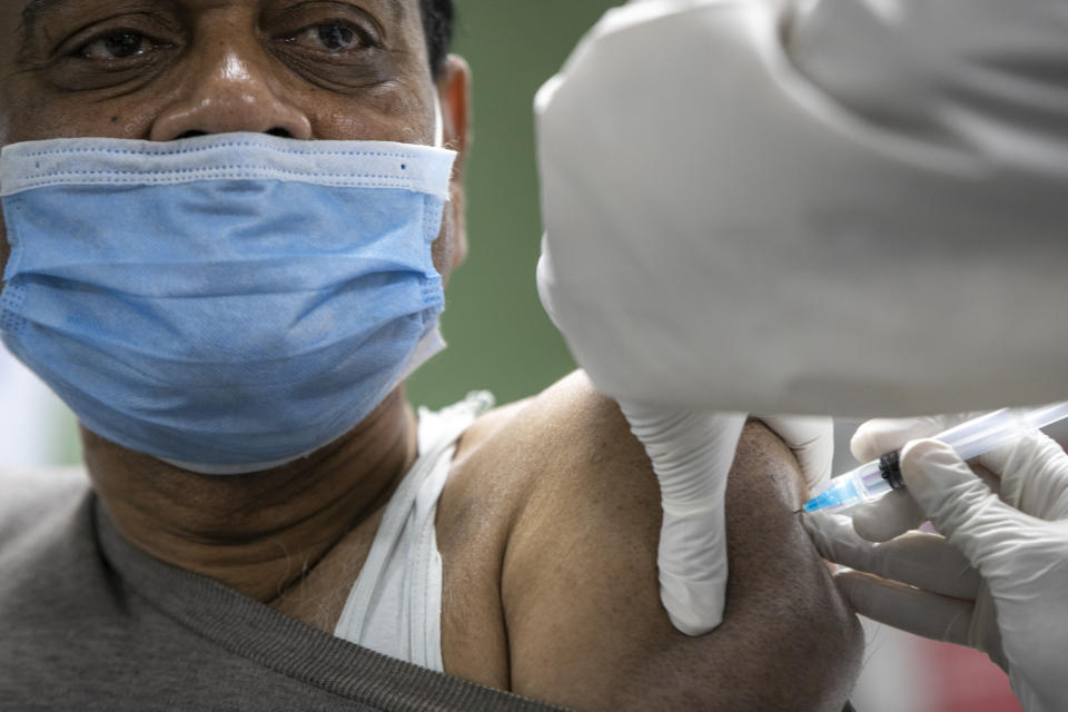 A Nepalese doctor receives AstraZeneca/Oxford University vaccine, at Teaching Hospital in Kathmandu, Nepal, Wednesday, Jan. 27, 2021. Thousands of health workers lined up across Nepal to get the coronavirus vaccine Wednesday as the Himalayan nation began its campaign to get the population vaccinated within three months. Neighboring India gifted Nepal 1 million doses of the vaccine manufactured under license by the Serum Institute of India. (AP Photo/Niranjan Shrestha)