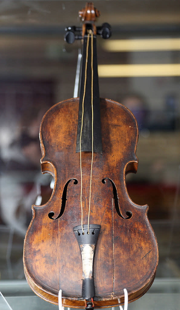 A very old violin close up with only 2 strings