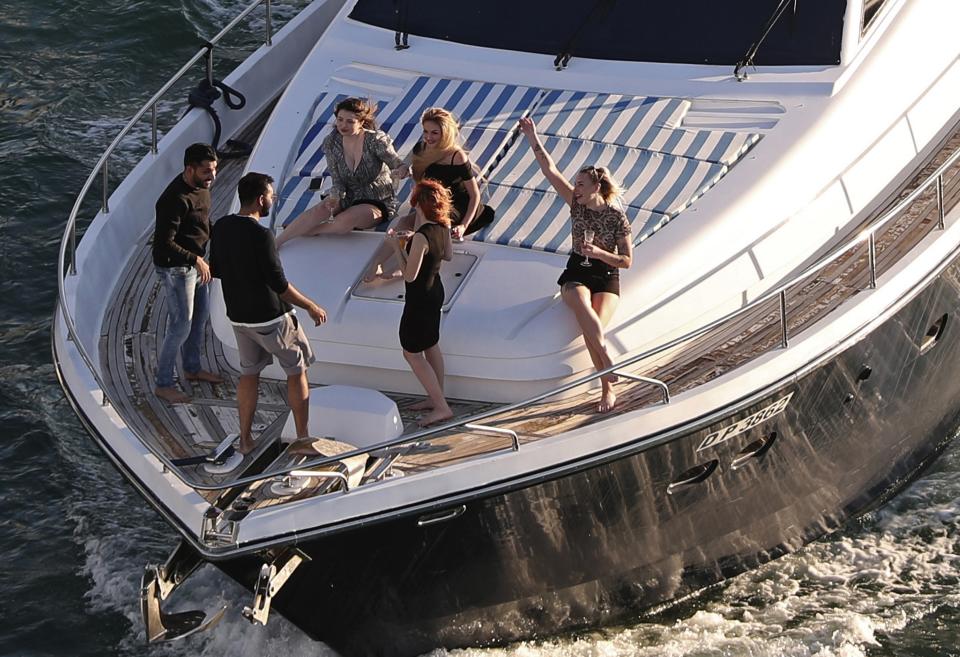 FILE - Tourists party on a yacht in Dubai, United Arab Emirates, Tuesday, Jan. 12, 2021. The globalized city-state of Dubai appears to be in the midst of a boom season. It's a surge in growth spurred on by one of the world’s highest vaccination rates and government moves to de-escalate tensions with regional rivals and lure foreign businesses. (AP Photo/Kamran Jebreili, File)