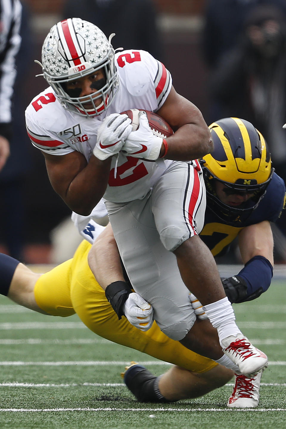 Ohio State running back J.K. Dobbins (2) escapes the tackle of Michigan defensive lineman Aidan Hutchinson (97) in the first half of an NCAA college football game in Ann Arbor, Mich., Saturday, Nov. 30, 2019. (AP Photo/Paul Sancya)