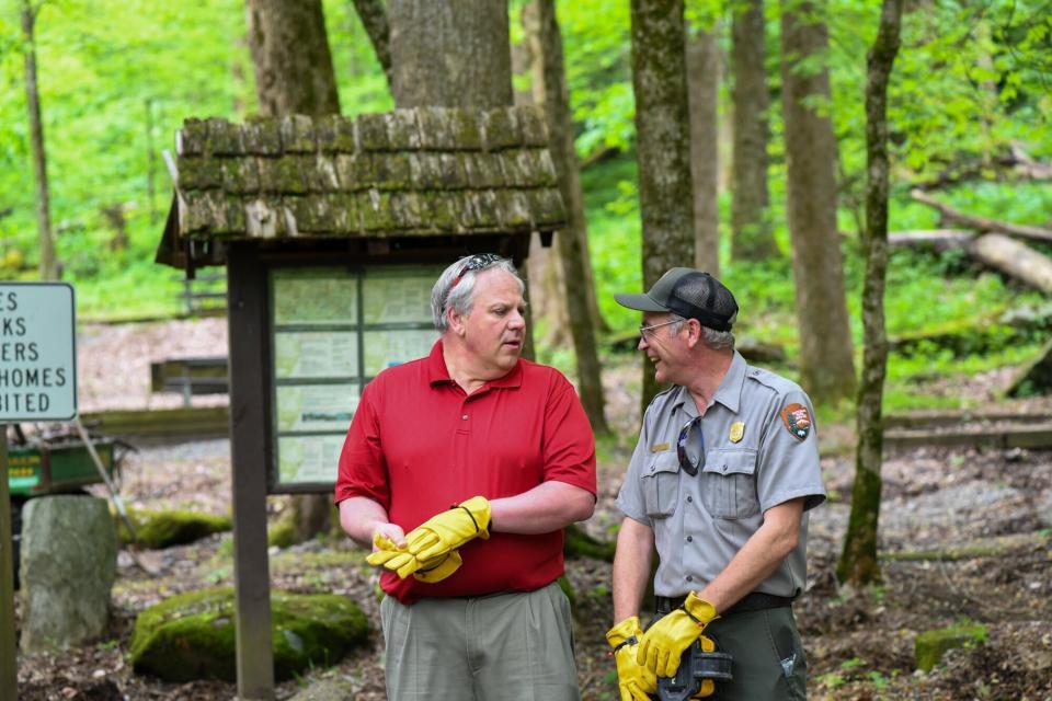 This Wednesday, May 6, 2020 image from a tweet by Interior Secretary David Bernhardt, the Interior Secretary visits with National Parks Service employees at Great Smoky Mountains National Park. While the Interior Secretary asked visitors to social distance when the park reopens on May 9, neither Bernhardt nor park staff wore face masks in the photos, as they talked and walked inches apart during his visit on Tuesday, May 5. (National Parks Service via AP)