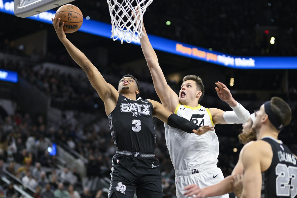 San Antonio Spurs' Keldon Johnson (3) goes to the basket against Utah Jazz's Walker Kessler (24) during the first half of an NBA basketball game Tuesday, Dec. 26, 2023, in San Antonio. (AP Photo/Darren Abate)