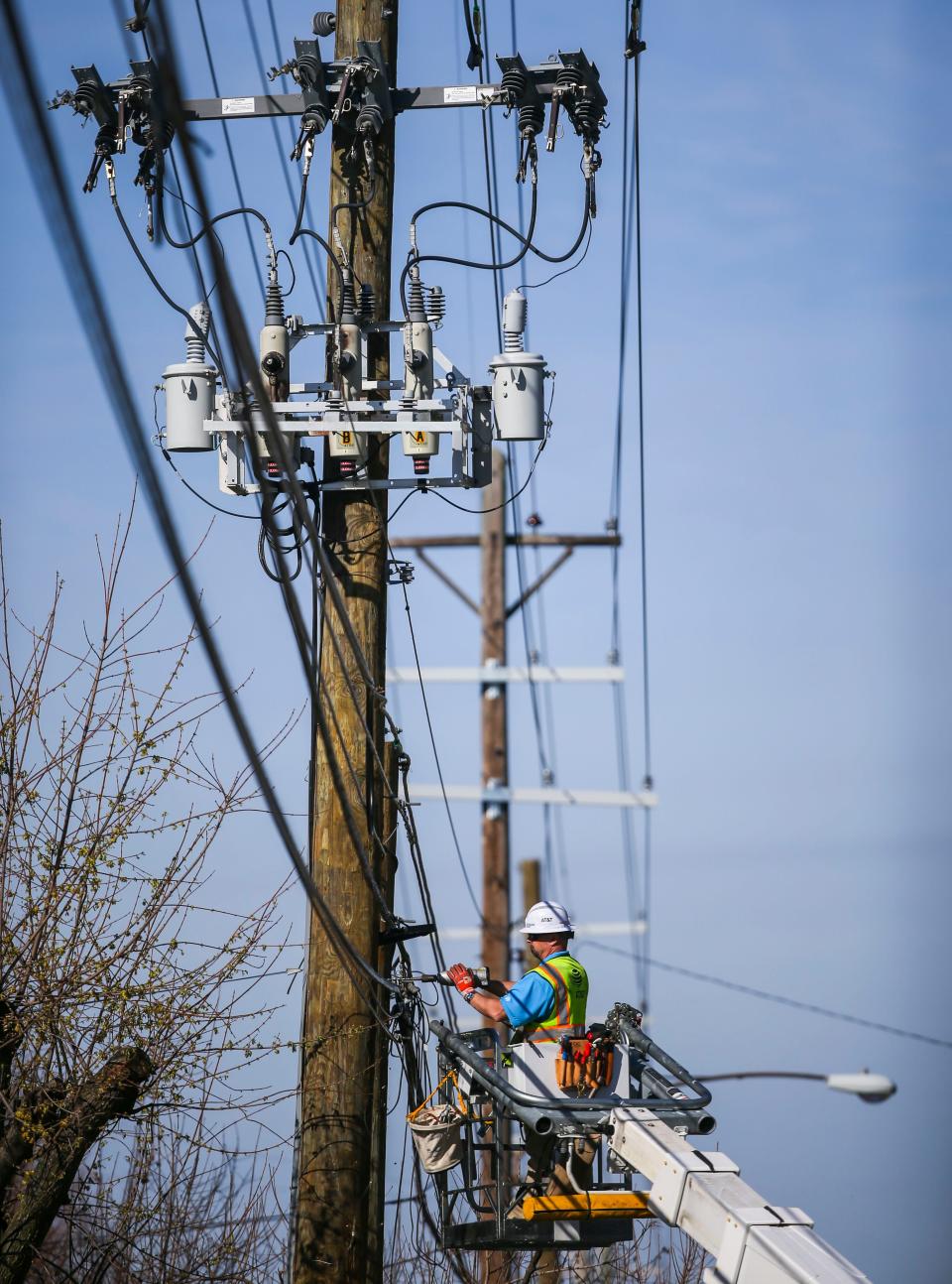 A lineman works on a utility pole.