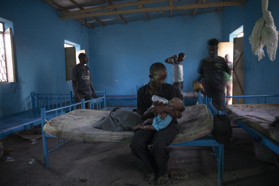 Tigrayan refugee Abraha Kinfe Gebremariam, 40, feeds his 4-month old daughter, Aden, inside their shelter in Hamdayet, eastern Sudan, near the border with Ethiopia, on March 21, 2021. Their village of Mai Kadra was the first known massacre of a conflict in which thousands of ethnic Tigrayans like his family have been killed. (AP Photo/Nariman El-Mofty)