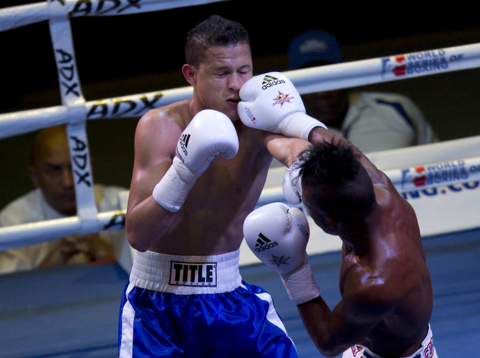 U.S. boxer Luis Arcon punches Cuban boxer Lazaro Álvarez, left, during their men's 60 kg boxing match in Havana, Cuba, Friday, April. 4, 2014. Boxers from the U.S. and Cuba went glove-to-glove on Cuban soil for the first time in 27 years Friday in a semipro World Series of Boxing clash (AP Photo/Ramon Espinosa)