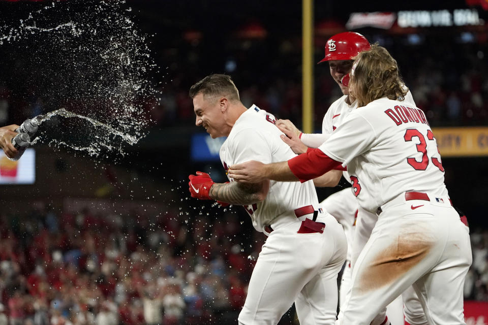 St. Louis Cardinals' Tyler O'Neill, left, is congratulated by teammates Brendan Donovan (33) and Andrew Knizner after being hit by a pitch with the bases loaded to end a baseball game against the Colorado Rockies Tuesday, Aug. 16, 2022, in St. Louis. The Cardinals won the game 5-4. (AP Photo/Jeff Roberson)