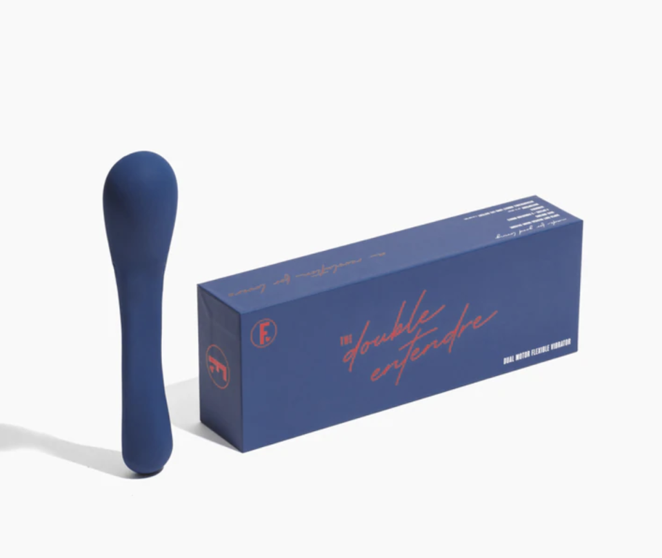 A navy blue vibrator, the Double Entendre, sits near its navy packaging box with red lettering, all on a white background