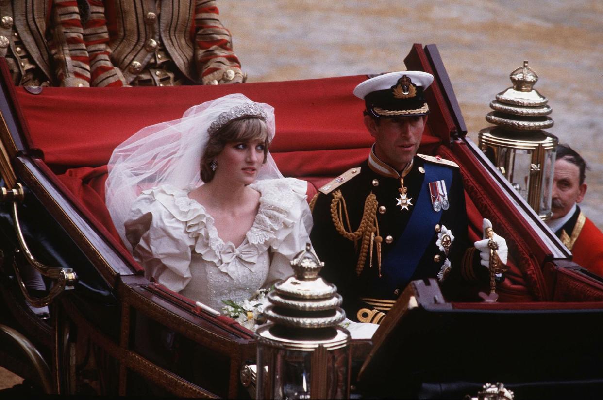 LONDON, ENGLAND - JULY 29: Prince Charles, Prince of Wales and Diana, Princess of Wales, wearing a wedding dress designed by David and Elizabeth Emanuel and the Spencer family Tiara, ride in an open carriage, from St. Paul's Cathedral to Buckingham Palace, following their wedding on July 29, 1981 in London, England. (Photo by Anwar Hussein/Getty Images)