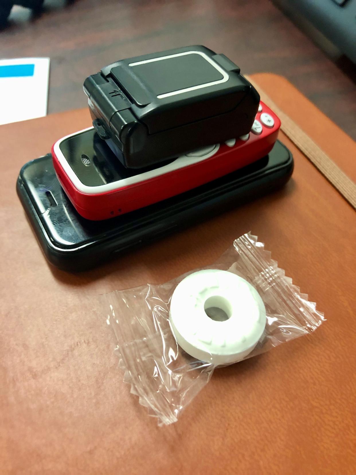 These tiny contraband cellphones found in Oklahoma prisons are shown last year next to a mint for comparison purposes.