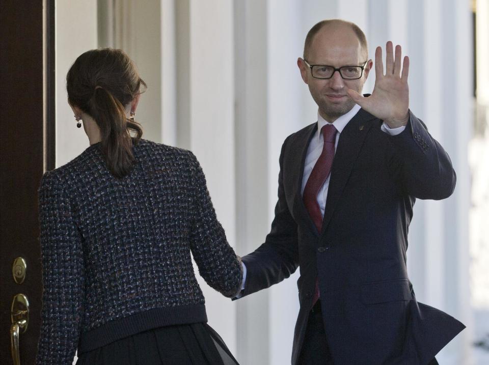 CORRECTS PHOTOGRAPHER TO PABLO MARTINEZ MONSIVAIS Ukraine Prime Minister Arseniy, right, waves as he is greeted by US acting Chief of Protocol Natalie Jones, left, during his arrival at the White House in Washington, Thursday, March 13, 2014. Arseniy is meeting with Vice President Joe Biden before traveling to New York to visit the United Nations. (AP Photo/Pablo Martinez Monsivais)