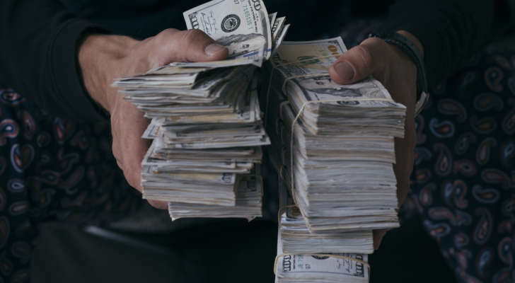 Man holding stacks of money. millionaire stocks.