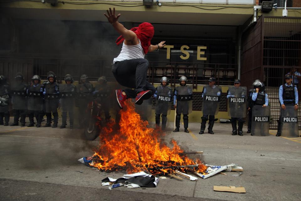 <p>A supporters of Libre Alliance presidential candidate Salvador Nasralla jumps over pyre of banners promoting Honduran President and current presidential Juan Orlando Hernandez in front of the Supreme Electoral Tribunal, during a protest claiming electoral fraud, in Tegucigalpa, Honduras, Wednesday, Nov. 29, 2017. (Photo: Fernando Antonio/AP) </p>