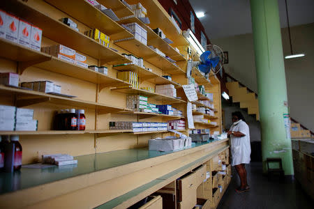 An employee talks on the phone inside a pharmacy in Havana, Cuba, December 1, 2017. REUTERS/Alexandre Meneghini